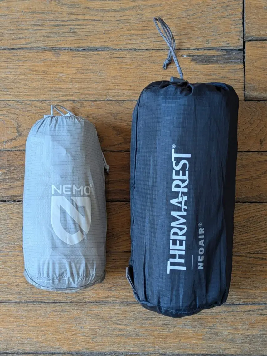 Deux matelas gonflables rangés dans leur sac de compression, côte à côte
