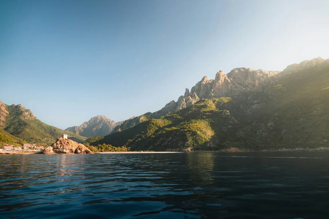 Côte rocheuse de Corse plongeant dans la mer sous le soleil