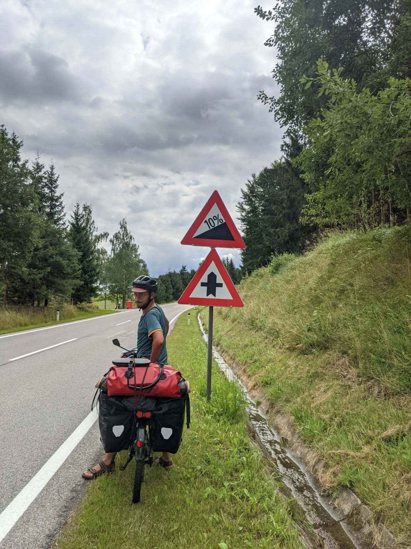 Velo de voyage vu de dos, sacoches arriere Ortlieb noires et sac rouge sur le porte-bagage