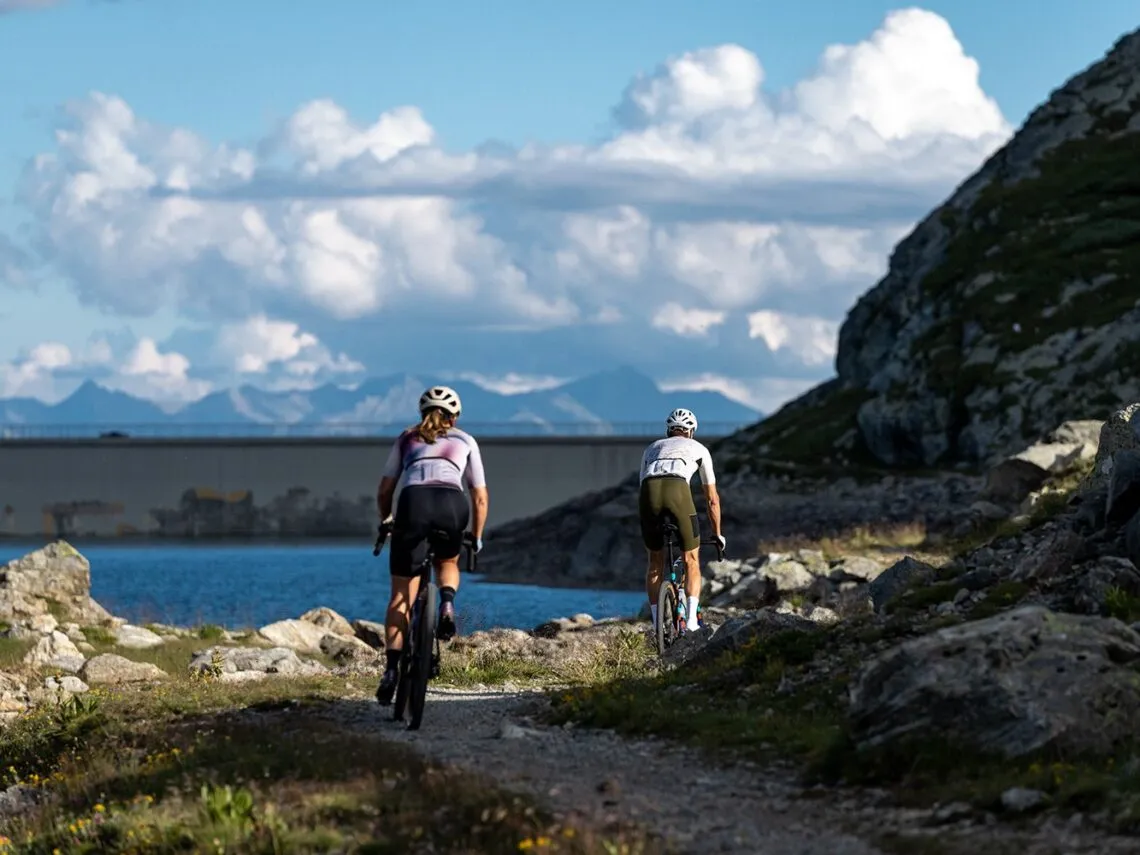 Deux cyclistes gravel sur un chemin de montagne au bord d'un lac