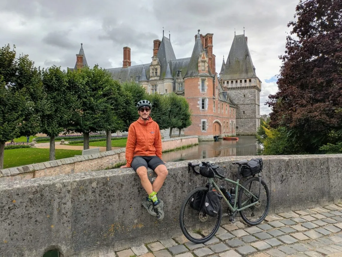 Vélo de bikepacking entièrement chargé de sacoches, posé devant un château