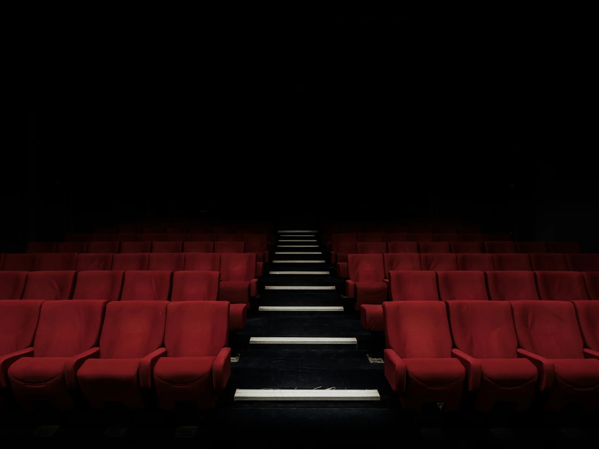 Rangees de sieges rouges dans une salle de cinema vide