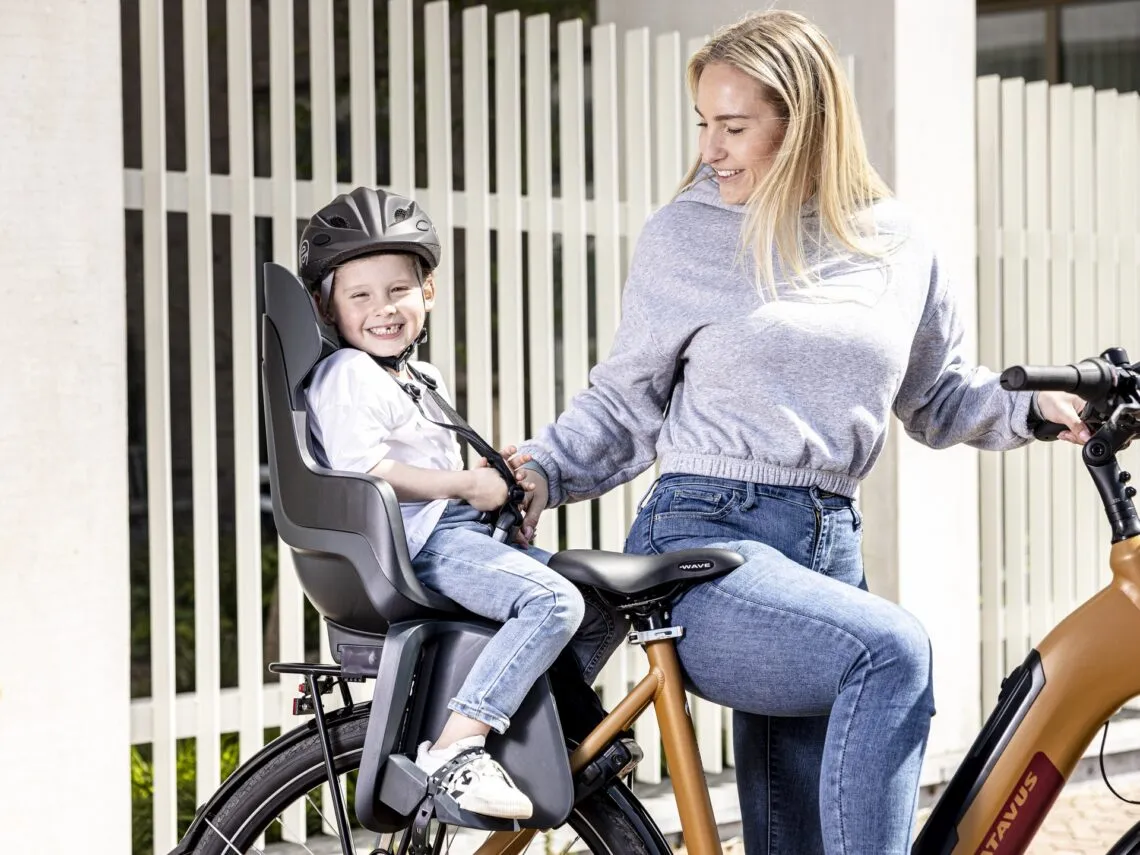 Siège vélo enfant arrière installé sur le porte-bagages d un vélo, enfant casqué assis dedans