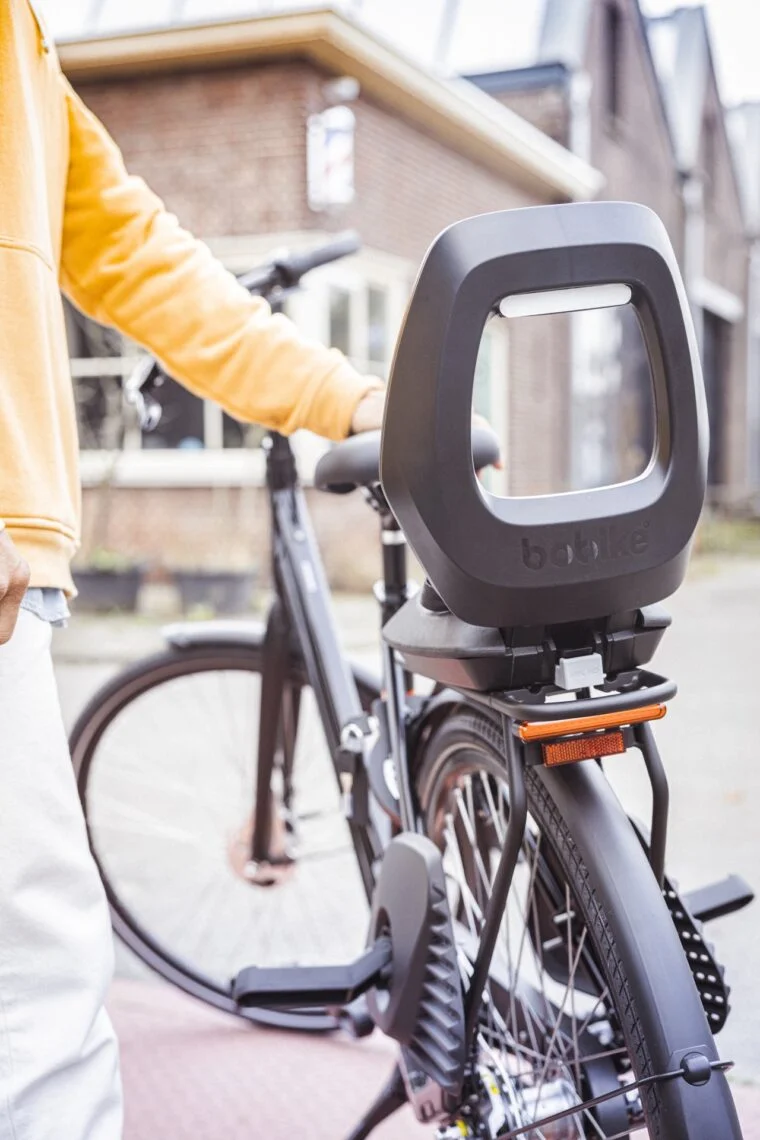 Siège vélo bébé arrière fixé sur le porte-bagages d'un vélo de ville