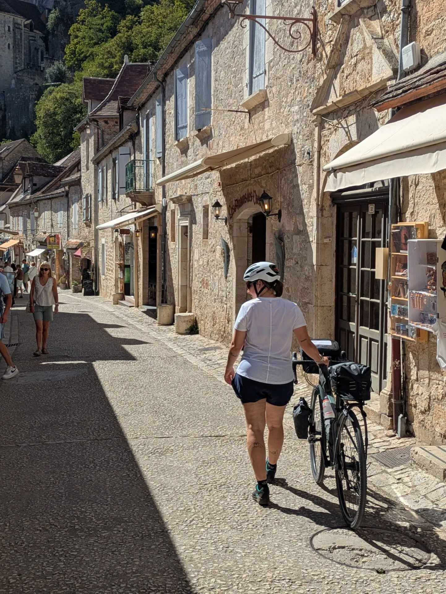 Morgane pousse son vélo dans la rue principale de Rocamadour