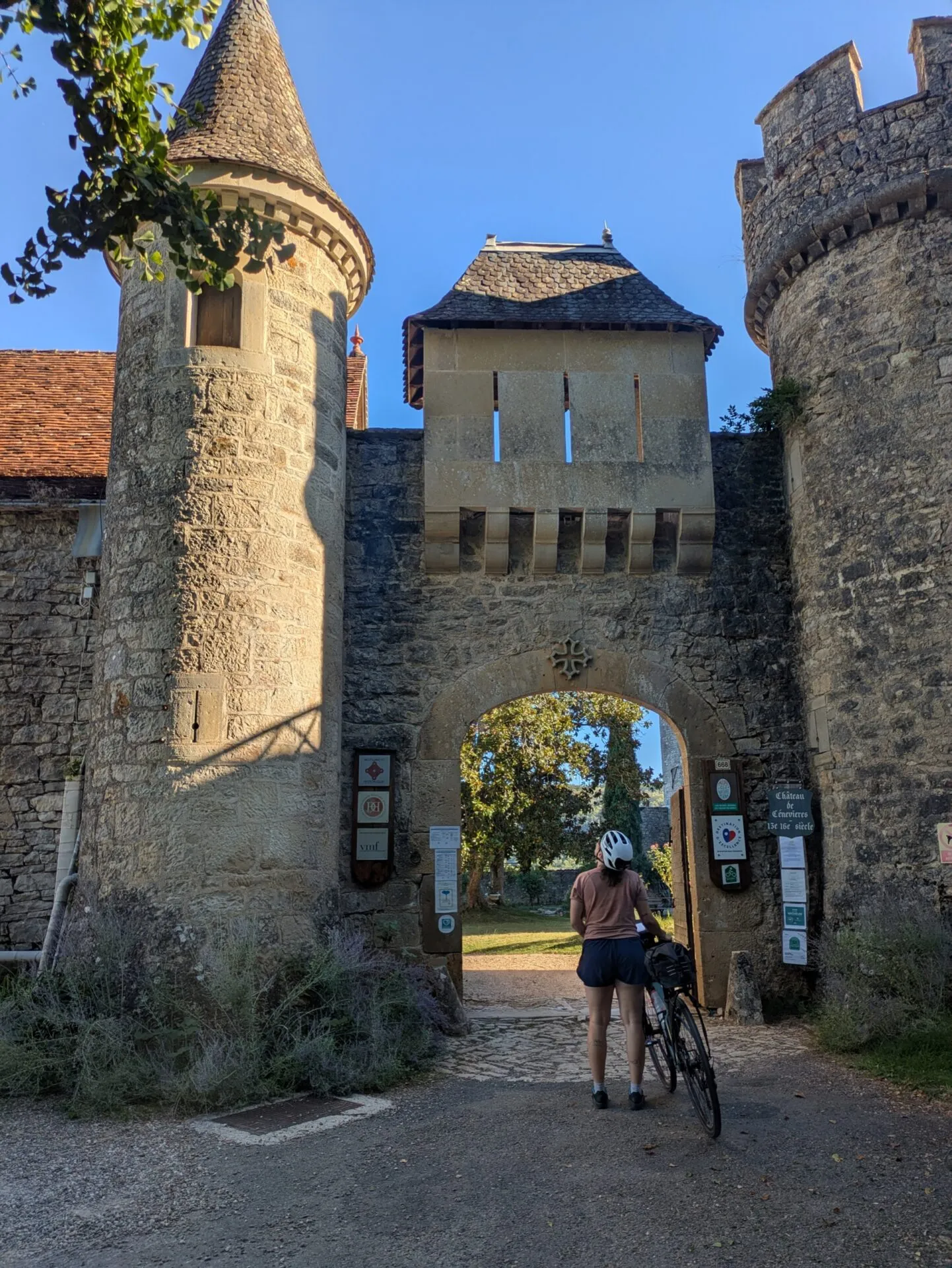 Morgane à vélo devant la porte fortifiée du château de Cénevières
